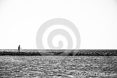 Lonely child walks on a thin coastline. Editorial Stock Photo