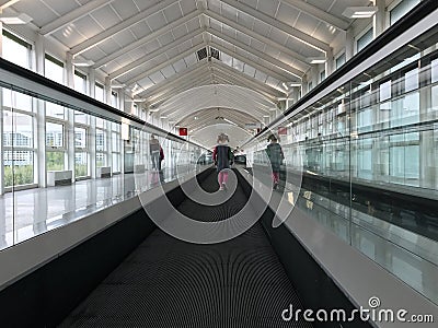 Lonely cute child travelling on travelator at airport terminal Stock Photo