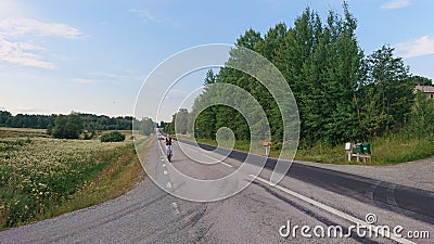 A lonely cyclist on a long Swedish road Stock Photo