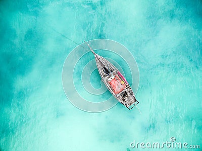 Lonely fishing boat in clean turquoise ocean, aerial photo Stock Photo