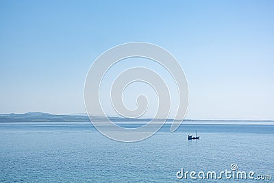 Lonely fishing boat in the vast ocean. Stock Photo