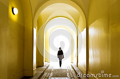 Lonely girl going forward through the yellow tunnel Stock Photo