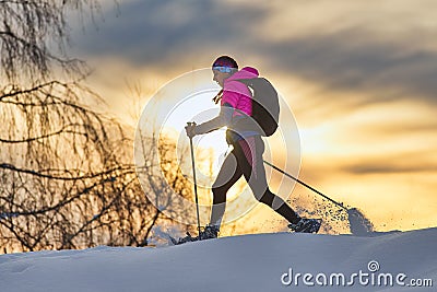 Lonely girl hike with snowshoes at sunset Stock Photo