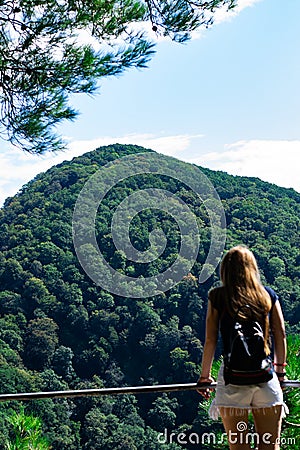 A lonely girl looks at the mountains on the other side. Low lying clouds and mountains Stock Photo