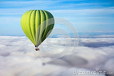 A lonely green hot air balloon floats above the clouds Stock Photo