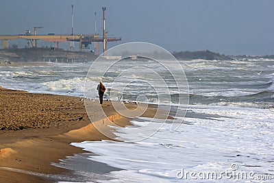 Lonely man on sandy beach at wintertime Editorial Stock Photo