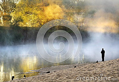 Lonely man standing soul searching on bank foggy misty river Stock Photo