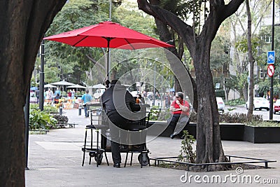 lonely man under the red umbrella in Mexico Editorial Stock Photo