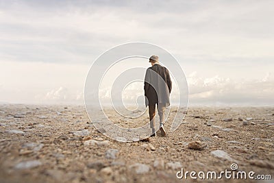 Lonely man walks towards an unknown destination in a desert Stock Photo