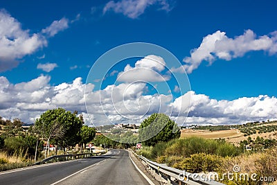 Lonely and moody road with clouds and an interesting light. Mountain road with dramatic colourful sky. Journey, outdoor, travel Stock Photo