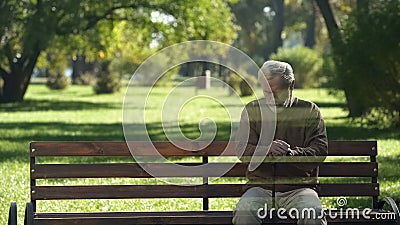 Lonely old man disappearing from bench, concept of death, transience of life Stock Photo