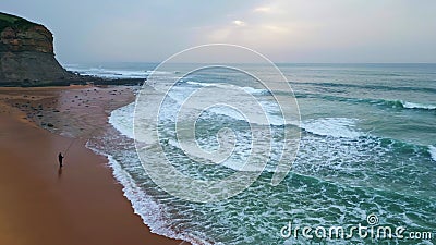 Lonely person fishing ocean side aerial view. Marine surf washing sandy beach Stock Photo