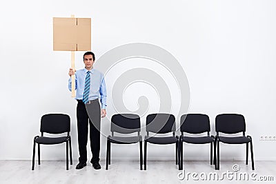 Lonely protesting businessman or employee holding placard Stock Photo