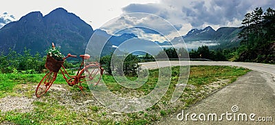 Lonely red decorative bicycle stands on a hillside, Geirangerfjord Stock Photo