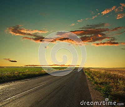 Lonely road leading to the horizon at sunset sky Stock Photo