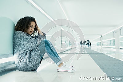 Lonely and sad girl seated on the ground Stock Photo