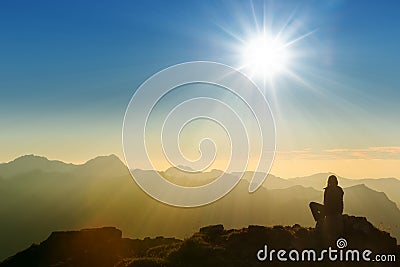 Lonely sad person sitting on mountain Stock Photo