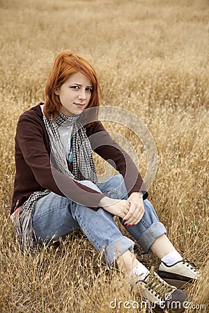 Lonely sad red-haired girl at field Stock Photo