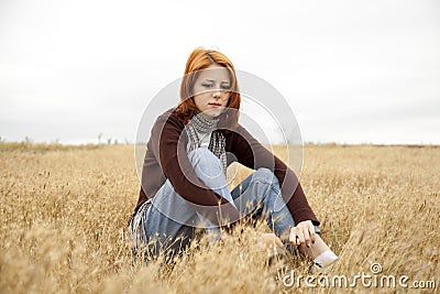 Lonely sad red-haired girl at field Stock Photo