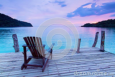 Lonely scene ; Single wooden chair in the port over sea at twilight Stock Photo