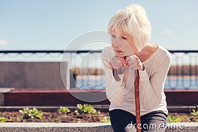 Lonely senior woman being absorbed into sad thoughts Stock Photo