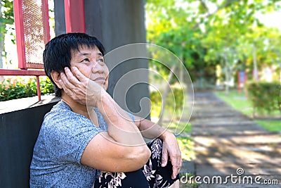 Lonely senior woman sitting outside Stock Photo