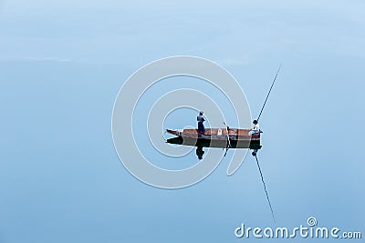 A lonely small boat with two young fishermen Stock Photo