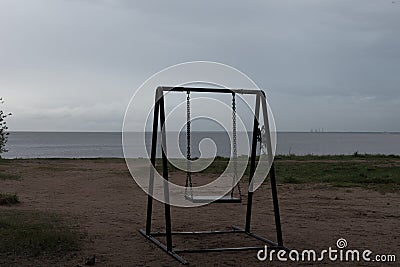 a lonely swing on the background of the gulf Stock Photo