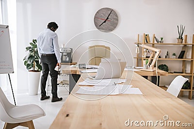 lonely tired businessman standing at conference hall with paperwork Stock Photo