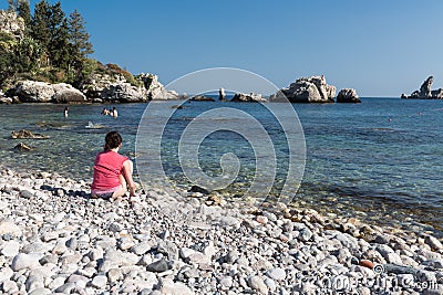 Lonely tourist making a phone call at the beach of Sicily, Italy Editorial Stock Photo