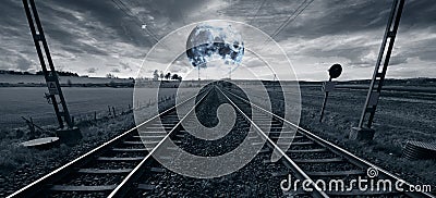 Lonely train track and a surreal full moon Stock Photo