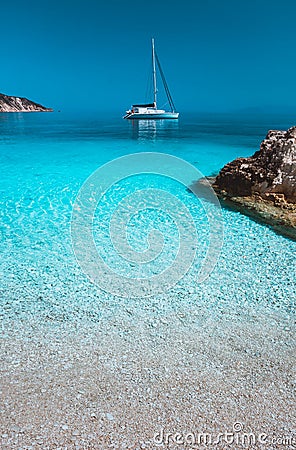 Lonely white sailing catamaran boat drift on calm sea surface. Pure azure clean blue lagoon with shallow water and Stock Photo