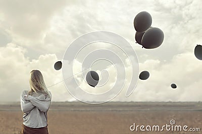 Lonely woman with blacks balloons hid her face Stock Photo