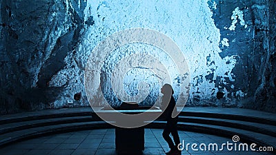 Lonely woman praying in the Salt Cathedral of Zipaquira is an underground Roman Catholic church built within the tunnels of a salt Editorial Stock Photo