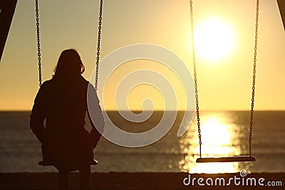 Lonely woman watching sunset alone in winter Stock Photo