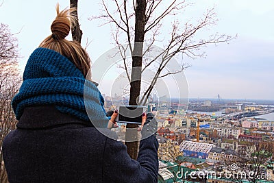 Lonely young lady makes landscape photo on her phone. Blurred downtown in the background. View from Artist& x27;s alley to the Editorial Stock Photo