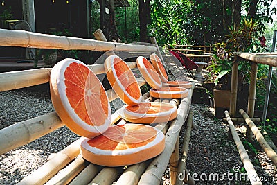 Long bamboo chairs and orange cushions Stock Photo