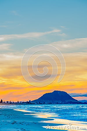 Long beach scene with landmark Mount Maunganui in distance Stock Photo