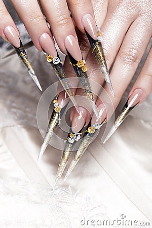 Long beautiful manicure with flowers on female fingers. Nails design. Close-up Stock Photo