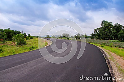 Long blank asphalt road with colorful green tree , grass on the side on blue sky background and white cloudy Stock Photo