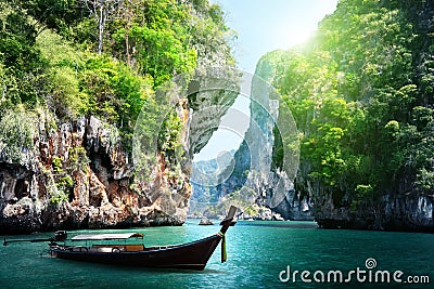 Long boat and rocks on railay beach in Thailand Stock Photo