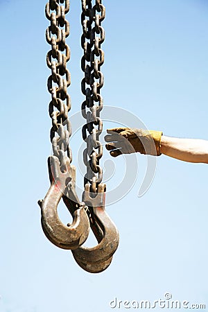 Long chains with hooks hanging vertically against blue sky Stock Photo