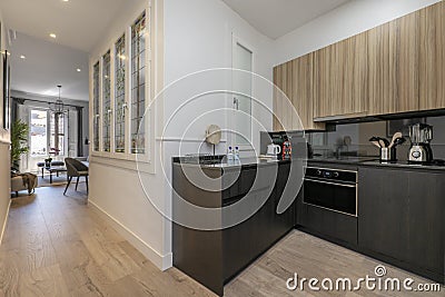 Long corridor that leads to a house with marble floors and stoneware walls with access to internal wooden stairs next to a walkway Stock Photo