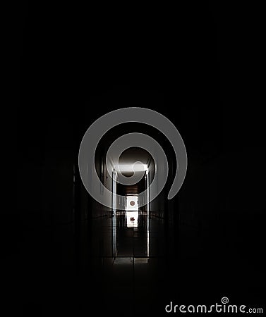 Long corridor or tunnel in haunted and ruined abandoned industrial building. Light in the end of tunnel. Stock Photo