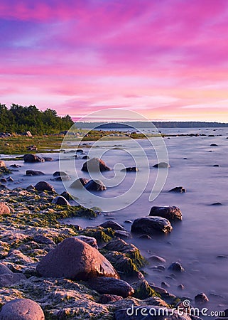 Long Exposure of the Baltic sea landscape. Stones, waves and sunset sun sky. The Gulf of Finland. Summer seascape Stock Photo