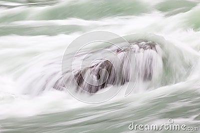 A Long Exposure Close Up of Rapids Flowing over a Rock in Niagara Gorge, Canada Stock Photo