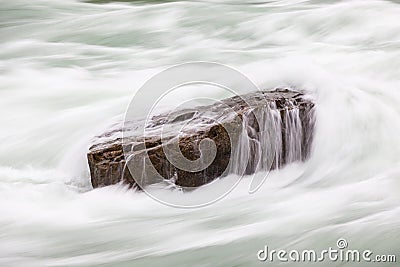 A Long Exposure Close Up of Rapids Flowing over a Rock in Niagara Gorge, Canada Stock Photo
