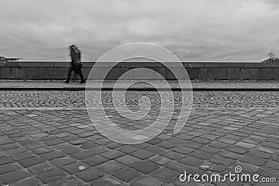 Long exposure of a pedestrian walking on a bridge on a rainy day Editorial Stock Photo