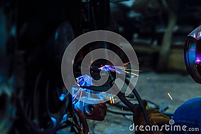 long exposure photo welder performs welding works of metal structures for custom cars Stock Photo