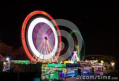 Long exposure picture of fairground rides in motion at the amusement park at night Stock Photo